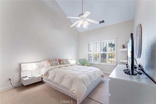 carpeted bedroom with ceiling fan and high vaulted ceiling