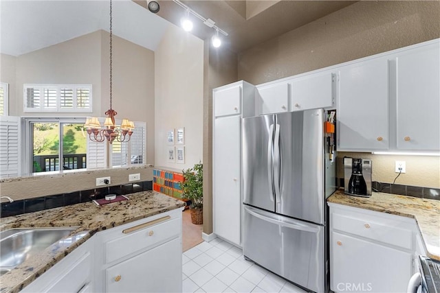 kitchen featuring white cabinetry, sink, lofted ceiling, light tile patterned floors, and appliances with stainless steel finishes