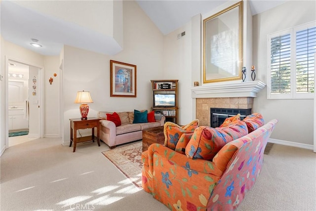 carpeted living room featuring lofted ceiling and a tiled fireplace