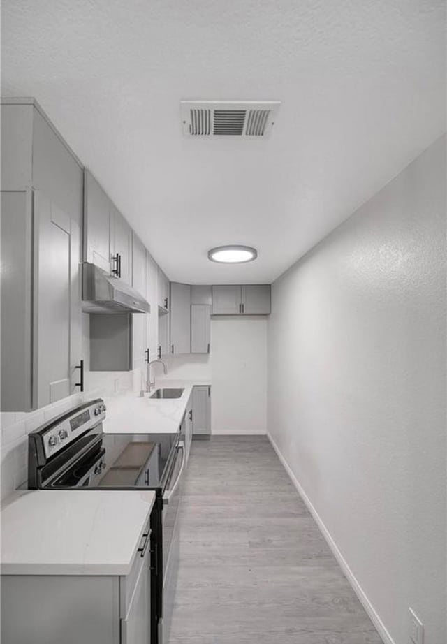 kitchen featuring light hardwood / wood-style floors, electric stove, sink, and gray cabinets