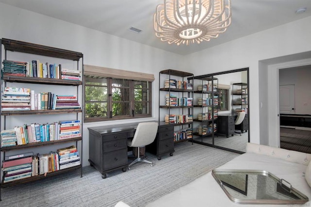 home office with carpet flooring and an inviting chandelier