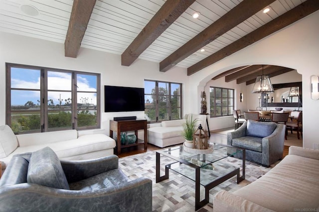 living room with vaulted ceiling with beams, a notable chandelier, hardwood / wood-style flooring, and wooden ceiling