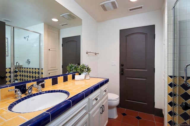 bathroom with vanity, tile patterned floors, toilet, and an enclosed shower