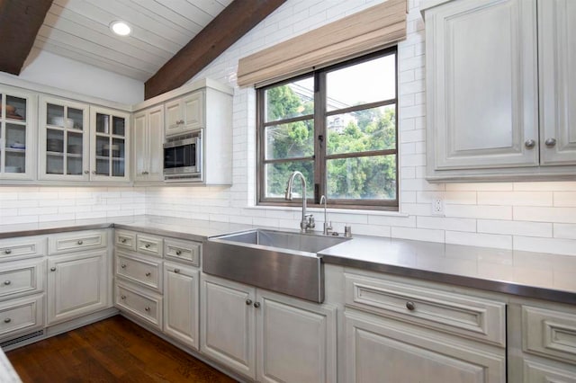 kitchen with sink, vaulted ceiling, white cabinets, decorative backsplash, and dark hardwood / wood-style floors