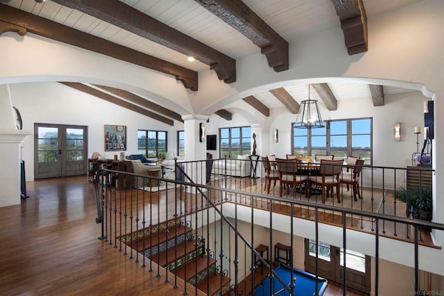 stairs with french doors, wood ceiling, wood-type flooring, lofted ceiling with beams, and an inviting chandelier