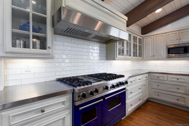 kitchen featuring tasteful backsplash, wall chimney range hood, stainless steel appliances, and dark hardwood / wood-style flooring