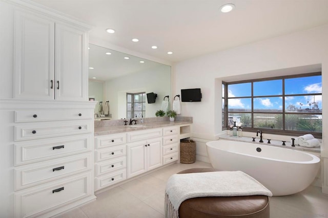 bathroom with vanity, a tub to relax in, plenty of natural light, and tile patterned flooring