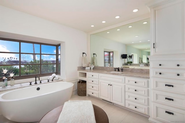 bathroom featuring vanity, tile patterned flooring, and a bathing tub