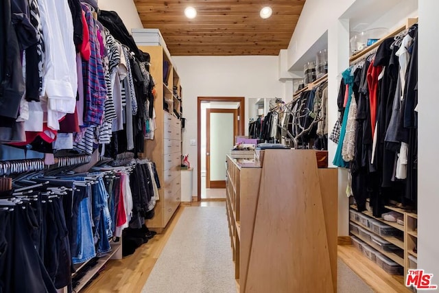 walk in closet featuring light hardwood / wood-style flooring and lofted ceiling