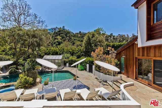 view of pool with a water slide and a patio area