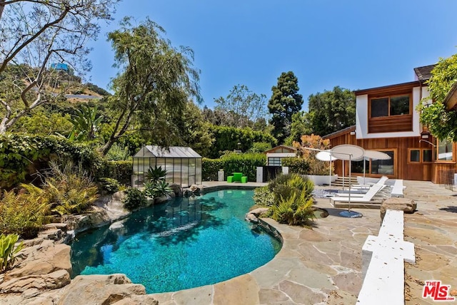 view of swimming pool with a patio area and an outbuilding