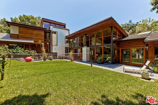 rear view of house featuring a lawn and a patio area