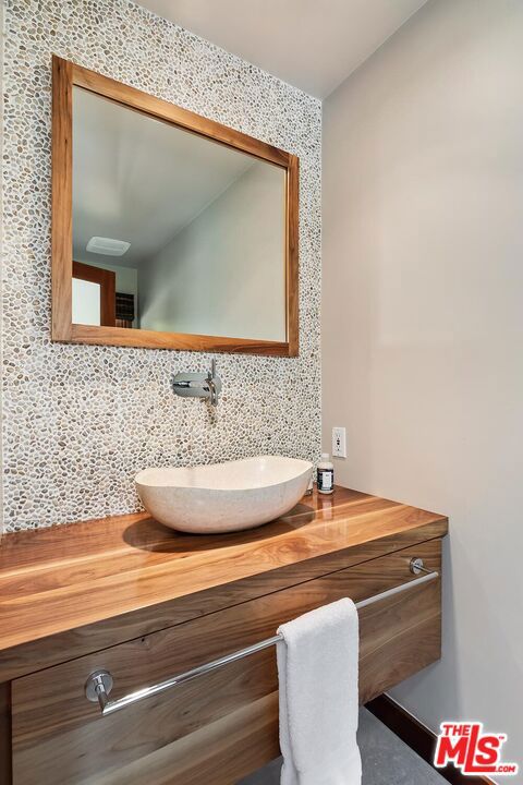 bathroom with vanity and decorative backsplash