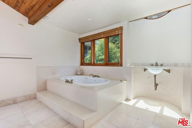 bathroom with a tub to relax in, lofted ceiling with beams, tile patterned flooring, and wooden ceiling