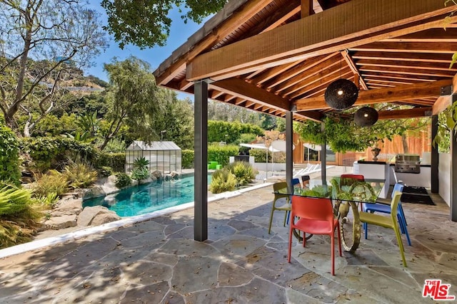 exterior space with exterior kitchen, a fenced in pool, ceiling fan, and area for grilling