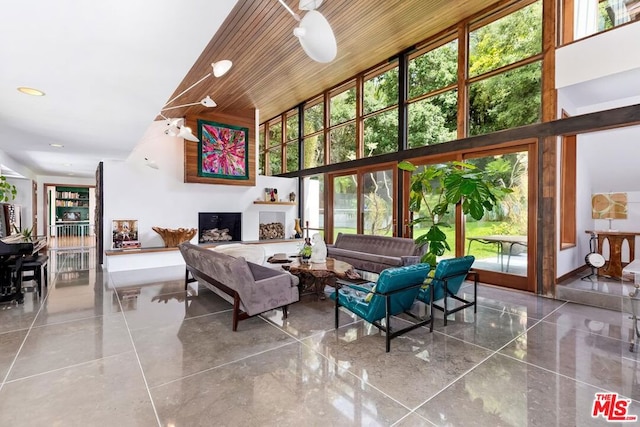 living room with a towering ceiling and wooden ceiling