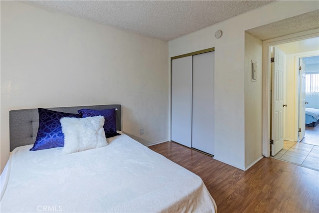 bedroom featuring a closet, hardwood / wood-style floors, and a textured ceiling