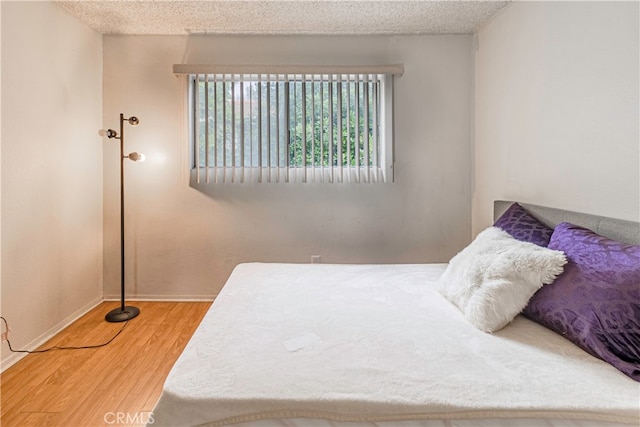 bedroom with wood-type flooring and a textured ceiling