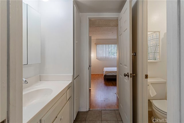 bathroom with vanity, hardwood / wood-style flooring, a textured ceiling, and toilet