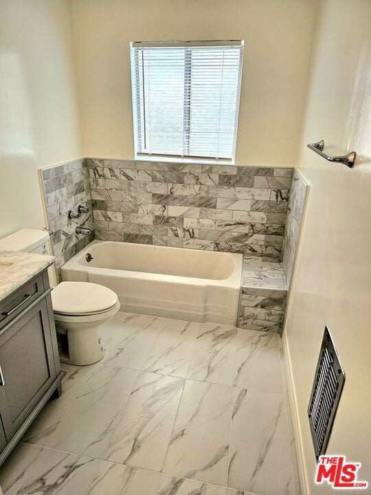 bathroom with a bathtub, tile walls, vanity, and toilet