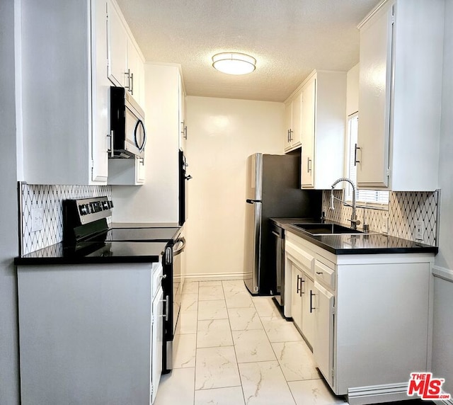 kitchen featuring white cabinets, sink, tasteful backsplash, a textured ceiling, and stainless steel appliances