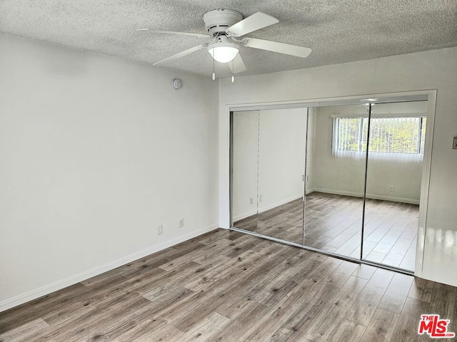 unfurnished bedroom with ceiling fan, a closet, and hardwood / wood-style floors