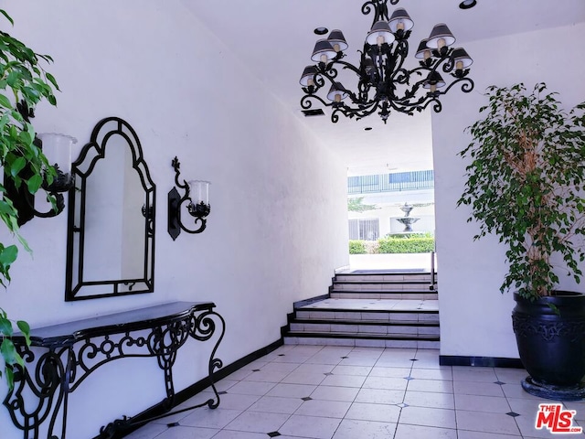 stairway with an inviting chandelier and tile patterned flooring