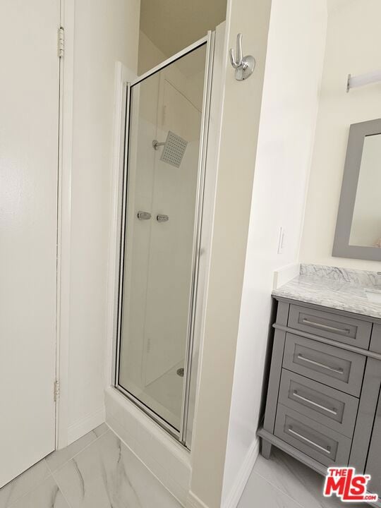 bathroom featuring walk in shower and vanity