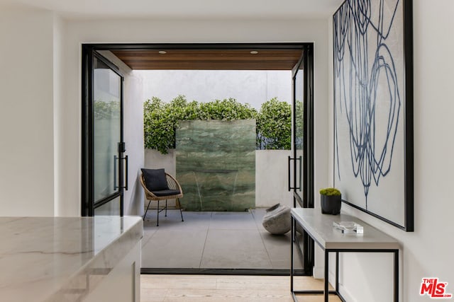 doorway with a healthy amount of sunlight and light hardwood / wood-style flooring