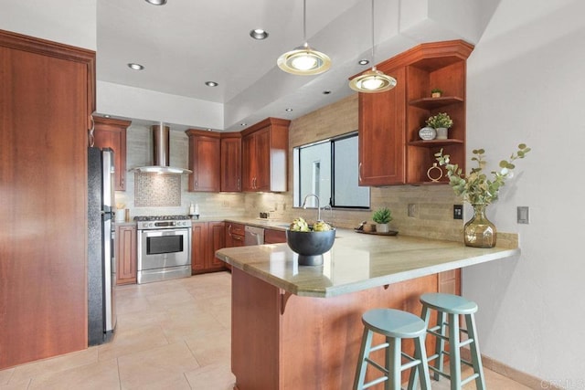 kitchen with appliances with stainless steel finishes, wall chimney exhaust hood, kitchen peninsula, and a kitchen breakfast bar