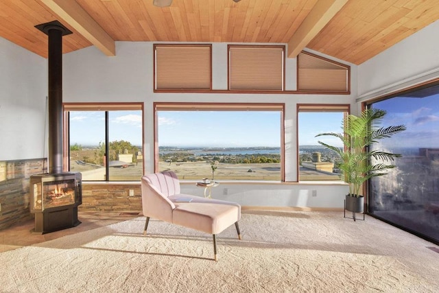 sunroom / solarium featuring wood ceiling, lofted ceiling with beams, and a wood stove