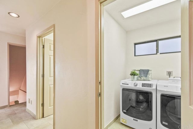 clothes washing area featuring light tile patterned floors and washing machine and dryer