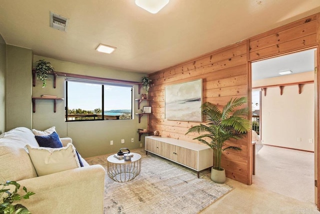 living room featuring wooden walls and light colored carpet