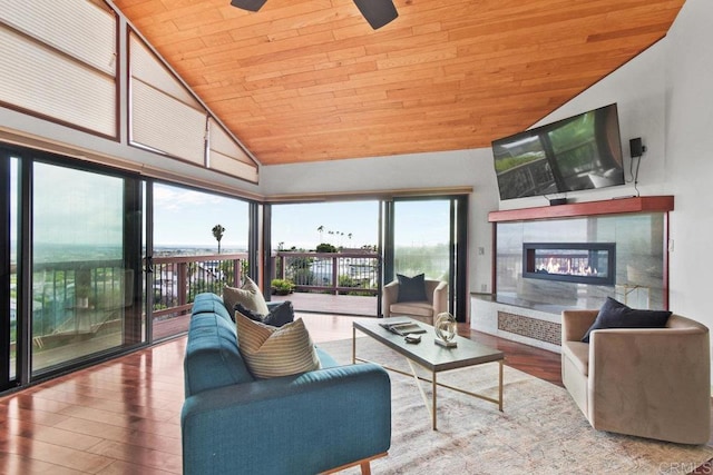 living room featuring ceiling fan, hardwood / wood-style flooring, a tiled fireplace, and wooden ceiling