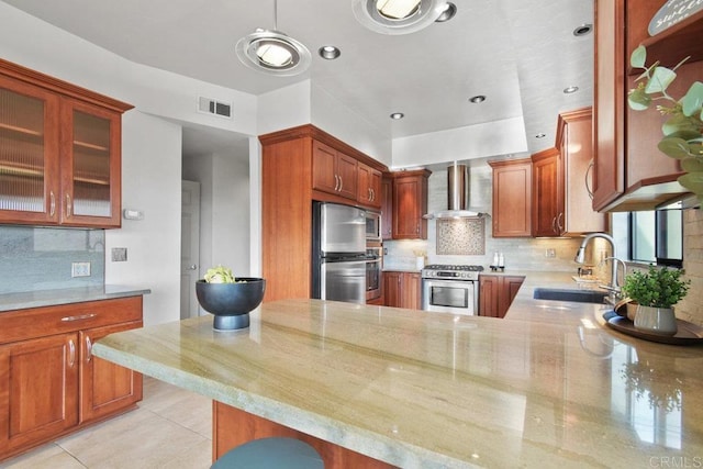 kitchen featuring appliances with stainless steel finishes, tasteful backsplash, kitchen peninsula, sink, and wall chimney range hood