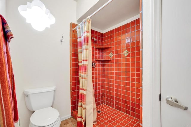 bathroom featuring toilet and curtained shower