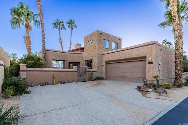 pueblo-style house featuring a garage