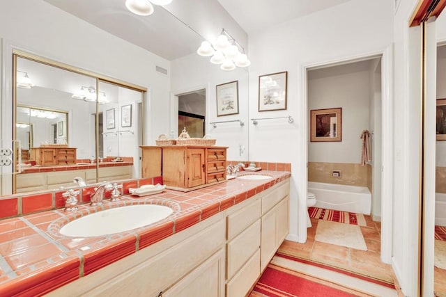 bathroom with vanity, toilet, and a washtub