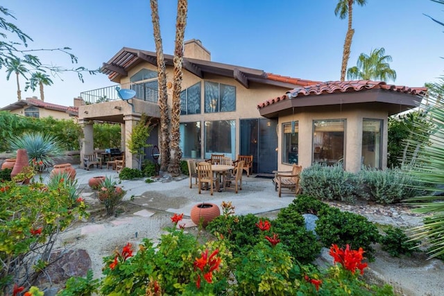 back of house featuring a balcony and a patio