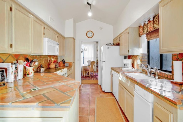 kitchen featuring tile counters, tasteful backsplash, sink, lofted ceiling, and white appliances