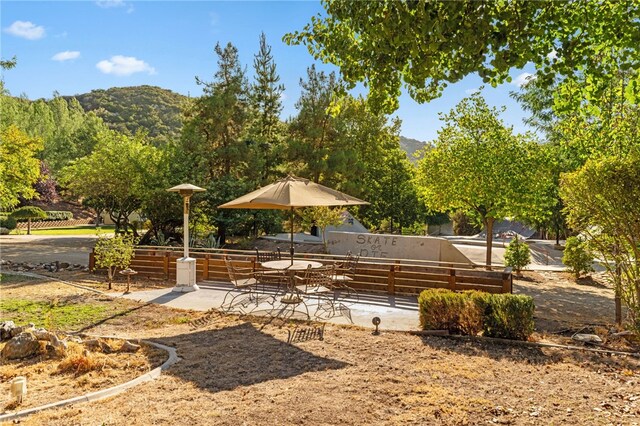 view of community with a patio area, a mountain view, and fence