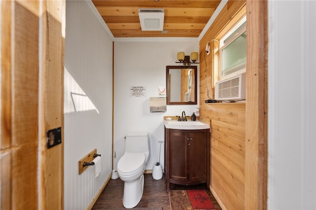 half bath with toilet, wood ceiling, cooling unit, baseboards, and vanity