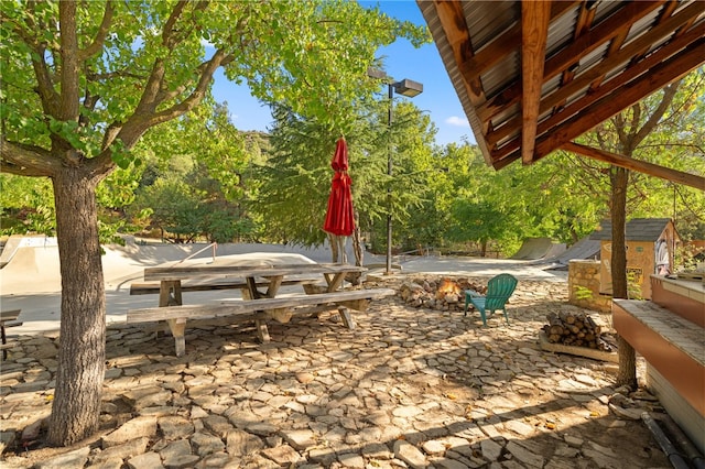 view of yard with a storage unit, an outdoor fire pit, and a patio area