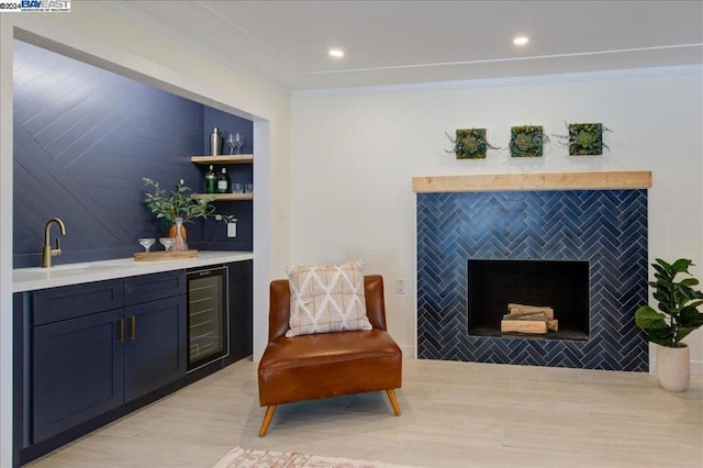 sitting room featuring tile walls, beverage cooler, and sink