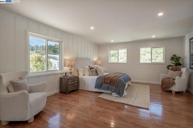 bedroom with hardwood / wood-style flooring and multiple windows