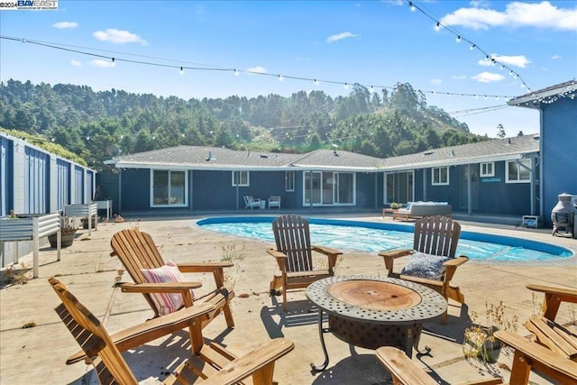 view of pool featuring a patio and an outdoor fire pit