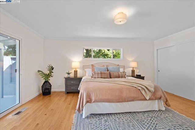 bedroom with access to outside, light hardwood / wood-style flooring, and ornamental molding