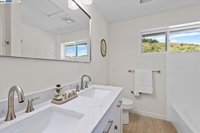 full bathroom featuring hardwood / wood-style floors, vanity, shower / bath combination, and toilet