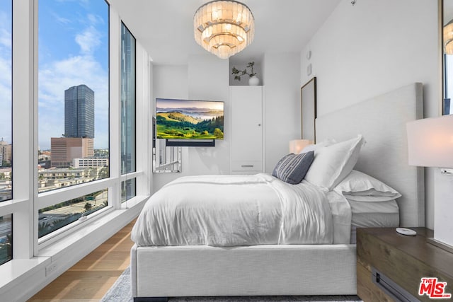 bedroom featuring hardwood / wood-style flooring and an inviting chandelier