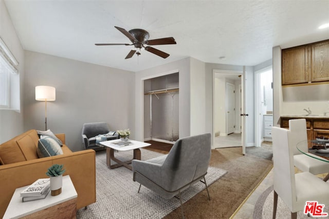 carpeted living room featuring ceiling fan